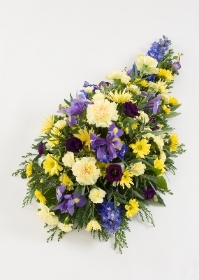 Single ended spray for a funeral. Yellow and purple.